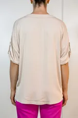 Blusa de viscosa en color beige, con escote en V, mangas cortas con dobladillo y corte holgado.