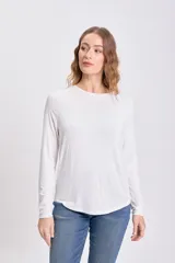 Remera de manga larga color blanco, con cuello redondo y corte holgado, confeccionada en viscosa.