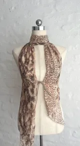Top halter con estampado animal print en tonos beige y marrón, con cuello alto y abertura en el pecho que se ajusta con lazos.