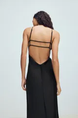 Vestido midi de tejido satinado color negro, con escote en pico, tirantes finos ajustables y diseño de espalda con tiras cruzadas.