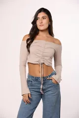 Top de algodón color marrón, con escote off-shoulder, mangas largas y detalle de frunce central con lazo ajustable.
