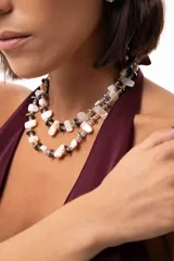 Collar de doble vuelta compuesto por piezas de nácar, discos de hematita en tonos dorados y plateados, y mostacillas. Incluye cadena de acero quirúrgico con cierre ajustable.