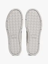 Zapatillas Tommy Jeans de corte bajo, confeccionadas en ante con paneles de malla y cuero sintético. Presentan un diseño en tonos gris y blanco con detalles en azul vibrante, cordones moteados y suela cupsole de goma con logo en bajo relieve.