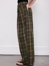 Pantalón de corte ancho y relajado, con estampa a cuadros en tonos marrones y azules. Cuenta con cintura elástica con cordón de ajuste y bolsillos laterales.