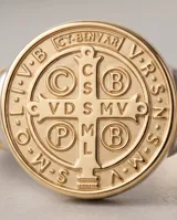 Anillo de plata y oro con diseño de San Benito, presenta una medalla circular grabada en el frente y detalles de alambre en los laterales del aro.
