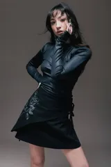 Minivestido negro con cuello alto y mangas largas. Presenta un drapeado lateral con lazos ajustables y un estampado de rosa en el frente.