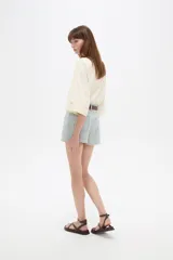 Short de jean de tiro alto con diseño de rayas verticales celestes y blancas, bolsillos laterales y vuelta en el ruedo.