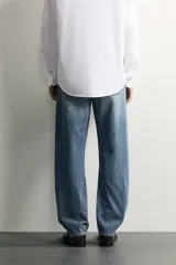 Jeans regular fit confeccionados en denim de algodón celeste con efecto lavado, de cinco bolsillos y cierre frontal con cremallera y botón.