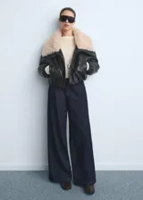 Pantalón de jean estilo wideleg de tiro medio, con pinzas delanteras, cierre de botón y cremallera, y cuatro bolsillos.