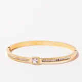 Pulsera rígida dorada con apliques de nácar y strass.