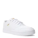 Championes Puma modelo Court Classic, de diseño inspirado en el tenis retro. Presentan una silueta de corte bajo en color blanco con detalles en dorado en el logo lateral y la lengüeta. Cuentan con una suela de goma resistente y plantilla SoftFoam+ para mayor amortiguación.
