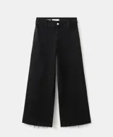 Jeans wide leg negros de tiro medio, con diseño de pernera ancha y terminación desmechada en el bajo.