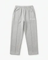 Pantalón de jogging baggy color gris melange, con cintura elástica, bolsillos laterales, costuras frontales en relieve y pequeño estampado con texto en la pierna izquierda.