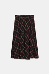 Falda midi de tiro alto con diseño acampanado y estampado de cuadros en tonos negro y marrón. Cuenta con cierre lateral oculto.