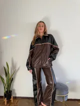 Campera oversize de cuero sintético color marrón y negro con cierre frontal y detalles en color crema.