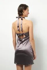 Vestido corto de satén color gris, sin mangas, con cuello alto y espalda descubierta con doble tira para atar.