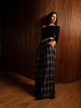 Pantalón tipo palazzo de corte amplio y tiro alto, con diseño de estampado a cuadros tipo tartán en tonos oscuros. Presenta pinzas en la cintura y bolsillos laterales.