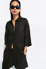 Shorts de tiro medio confeccionados en 100% lino, de color negro. Presentan cintura elástica con volado y cordón ajustable, además de bolsillos delanteros aplicados.
