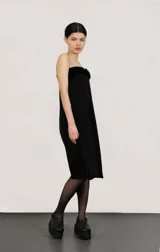 Falda larga negra con tajo lateral y pretina con trenza de terciopelo.