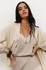 Colgante con cadena fina negra y dije dorado con forma irregular.