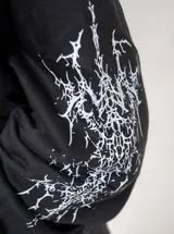 Buzo canguro negro con capucha, confeccionado en algodón, con estampado frontal y en las mangas de un ángel en color blanco.