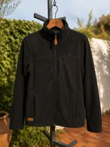 Campera de polar azul marino con cierre frontal completo, cuello alto, bolsillos laterales y un bolsillo vertical en el pecho. Presenta detalles en cuero sintético en el tirador del cierre y una etiqueta de marca en el ruedo.