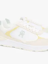 Zapatillas Tommy Hilfiger de mujer, color blanco con detalles en amarillo y verde. Presentan el logo de la marca en el lateral y están confeccionadas con una mezcla de texturas.