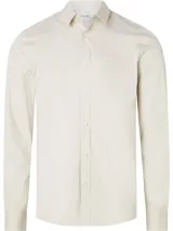 Camisa de manga larga color blanco hueso, de corte slim, con cuello tradicional y cierre frontal de botones.