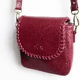 Mini cartera bandolera de cuero, de formato compacto y diseño atemporal con solapa frontal y costuras artesanales decorativas en el borde. Cuenta con el logotipo de la marca grabado en la parte delantera y correa larga regulable.