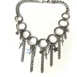 Collar plateado con cadena de eslabones gruesos y dijes colgantes de estrellas, puntas y bolitas.