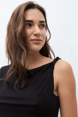 Top sin mangas color bordó, con escote asimétrico drapeado y ajuste al cuerpo.