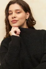 Polera beige de tejido de punto con cuello alto y mangas largas.