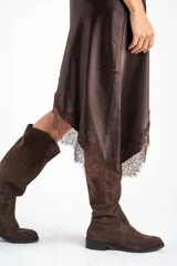 Vestido midi de satén negro con escote en V y tirantes finos. Presenta un diseño asimétrico en el ruedo con detalle de encaje aplicado.