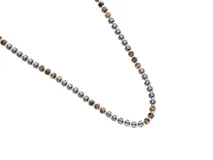 Collar de diseño minimalista compuesto por una alternancia de cuentas de acero inoxidable y piedras naturales en tonos tierra.