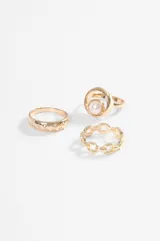 Set de tres anillos plateados de diseño variado: uno con perla central, uno tipo cadena de eslabones y uno liso con pequeñas incrustaciones de cristales.