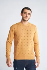 Sweater de punto color mostaza con cuello redondo y mangas largas. Presenta un estampado de pequeños motivos repetidos en contraste y un logo bordado en el pecho.