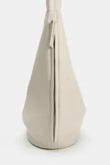 Bolso de hombro de gran tamaño color beige, con diseño hobo de líneas suaves, asa ancha integrada y cierre superior con imán.