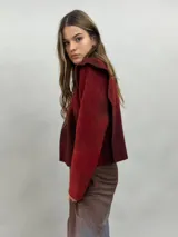 Buzo de lana merino afieltrada con diseño artesanal de efecto degradado en tonos violeta y fucsia. Presenta cuello alto, hombreras marcadas y corte holgado.