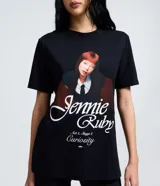 Remera negra de algodón con cuello redondo y mangas cortas. Presenta un estampado gráfico frontal con la imagen de la cantante Jennie y la inscripción 'Jennie Ruby' junto al texto 'Act 1, Stage 2 Curiosity'.