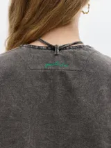 Chaleco gris oscuro de denim con corte entallado y cuello en V.