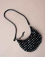 Bolso de mano tipo hobo, confeccionado en gamuza color marrón oscuro, decorado con tachas metálicas circulares en toda su superficie. Cuenta con un asa corta integrada y un diseño curvo distintivo.