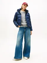 Campera térmica Tommy Hilfiger de corte informal, confeccionada en nailon ligero con relleno de plumón y acabado repelente al agua. Presenta capucha fija con cordón ajustable, cuello levantado, cierre frontal de cremallera y dos bolsillos delanteros con botón a presión. Incluye parche distintivo de la marca en la manga.