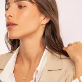 Conjunto compuesto por cadena fina y dije circular con circonia central engastada en oro 18k.