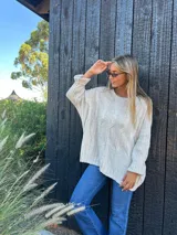 Buzo oversize color beige, con diseño de ochos en el frente y liso en la espalda. Confeccionado en lana y poliamida.