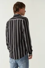 Camisa de mangas largas con estampado a rayas verticales en tonos verde oliva, blanco y azul. Corte regular y logo bordado en el pecho. Confeccionada en viscosa.