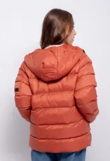 Campera puffer de nylon color negro con capucha, cierre frontal y bolsillos laterales. Presenta un bolsillo adicional con solapa en la manga izquierda y puños elásticos.