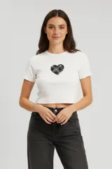 Remera de algodón blanca de corte crop, con cuello redondo y aplique central en forma de corazón con estampado de cuadros escoceses.