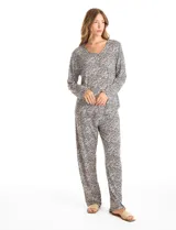 Conjunto de pijama compuesto por una remera de manga larga con escote en V, abertura frontal con botones y bolsillo aplicado, y un pantalón con cintura elástica y lazo de ajuste. Presenta un estampado animal print en tonos neutros.