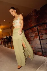 Pollera larga de gasa color bordó, con diseño de tiro alto, base fruncida y tajo lateral profundo decorado con volados verticales.