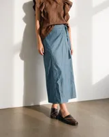 Falda larga de denim color celeste, de corte recto y diseño envolvente con tiritas para anudar en la cintura. Presenta costuras a la vista.